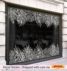 an image of a restaurant window with palm leaves on it