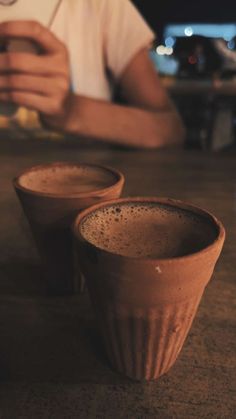 two brown cups sitting on top of a wooden table