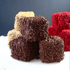 four pieces of chocolate cake sitting on top of a white plate next to each other