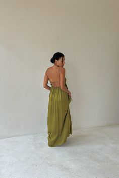 a woman in a green dress standing back to back with her hands on her hips