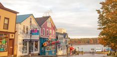 a row of shops on the side of a street next to a body of water