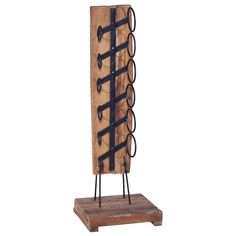 a wooden rack with black iron handles and hooks on the top is holding several pairs of scissors