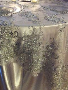 the table cloth is covered with silver sequins and beadwork on it