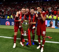 the soccer players are celebrating with the trophy