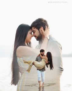 a man and woman standing next to each other on the beach with their arms around each other