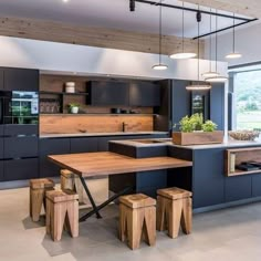 a kitchen with an island, table and stools in the middle of the room