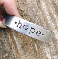 "We have this hope as an anchor for the soul, firm and secure. It enters the inner sanctuary behind the curtain, where our forerunner, Jesus, has entered on our behalf. He has become a high priest forever, in the order of Melchizedek." Hebrews 6:19-20 NIV Hold onto hope. It's firm. It's secure. And it's sealed with a promise ⚓️ Hand stamped on a silver cuff bracelet, this bracelet is a daily reminder to hold onto * hope * ⚓️ Bracelet Length: 1/2" x 6" happy shopping & God bless, Joy & Hannah Love Designs Hebrews 6, Affirmation Bracelets, Hope Bracelet, Handstamped Bracelet, Stamped Bracelet, High Priest, The Anchor, Christian Jewelry, Silver Cuff Bracelet