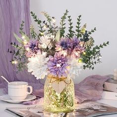 a vase filled with purple and white flowers on top of a table