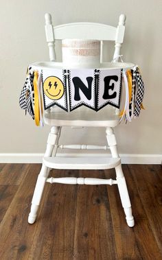 a white rocking chair with a yellow and black one banner on the back that says'one '