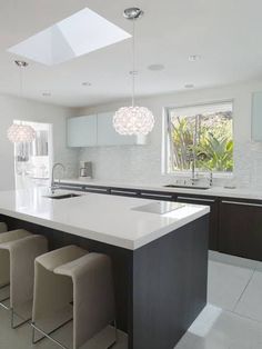 a large kitchen with an island and bar stools