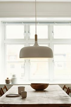 a dining room table and chairs with a large white light hanging over it's head