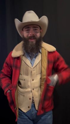 a man with a beard wearing a cowboy hat and holding a knife in his hand