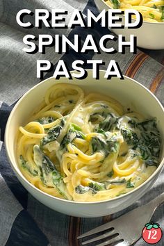 two bowls filled with pasta and spinach on top of a table next to silverware