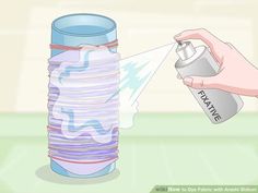 a person spraying disinfectant onto a stack of paper towels with a spray bottle