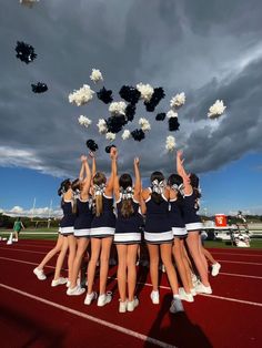 a group of cheerleaders standing on top of a track