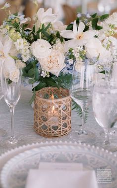 a table set with white flowers and candles