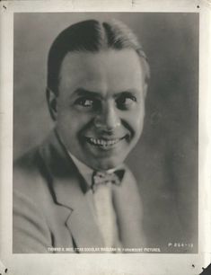 an old black and white photo of a man with a smile on it's face