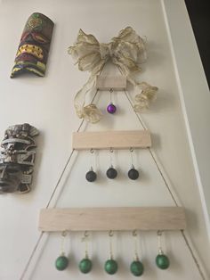 a christmas tree made out of wood with bells hanging from it's sides and decorations on the wall