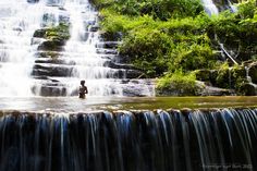 a man standing in the middle of a waterfall