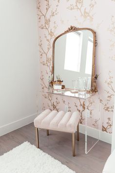 a mirror sitting on top of a wooden table next to a white bench in a room