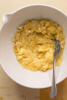 a white bowl filled with oatmeal and a fork