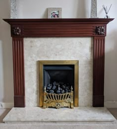 a fire place in a living room with a painting on the wall above it's mantle