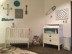 a baby's room with a crib, dresser and other items on the wall