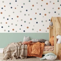 a child's bedroom with polka dot wallpaper and bedding in neutral colors