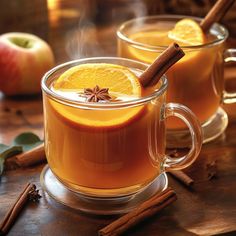 two mugs filled with cinnamon and apple cider