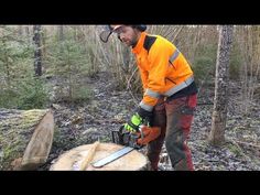 a man in an orange jacket using a chainsaw