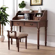 a desk with a chair and potted plant in the corner next to it on top of a hard wood floor