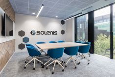 a conference room with blue chairs and a wooden table