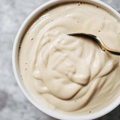 a spoon in a white bowl filled with cream