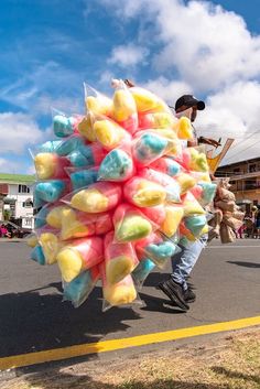 a man is walking down the street carrying candy