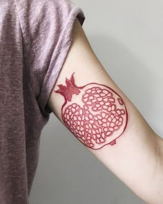 a tattoo on the arm of a person with a pomegranate in it