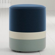 a blue and white ottoman sitting on top of a hard wood floor