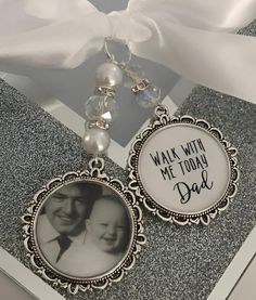 a keychain with an image of a man and woman on it next to a white ribbon