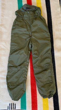 Vintage military winter flying suit pants. Manufactured in 1963 by Skyline Clothing Corp. in good vintage condition. Commas zippers, in good working order. Double zip in the front, one zippered pocket on the front of each lower leg. Snap pockets in the back. Obviously this is the lower half of a flying suit. Jacket is not included. Size marked 34L. Waist is approximately 33-34 and the inseam is approximately 32 inches. Please review all photos, descriptions and measurements. Feel free to ask que Vintage Military Pants, Combat Shirt, Flight Suit, Military Pants, Russell Athletic, Lower Leg, Vintage Winter, Vintage Military, Mens Trousers