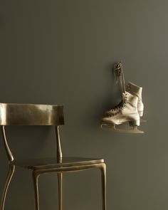 a pair of ice skates hanging on the wall next to a chair