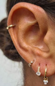 a close up of a person's ear with three small diamonds on it