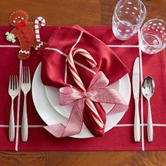 a place setting with candy canes and gingerbread cookies