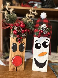 two wooden christmas decorations sitting on top of a table