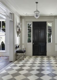 an entryway with a checkered floor and black door