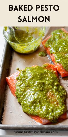 baked pesto salmon on a baking sheet with green sauce in the background and text overlay that reads how to make baked pesto salmon