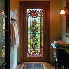 a stained glass door in a bathroom next to a sink