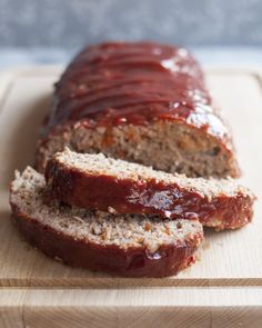 sliced meatloaf sitting on top of a cutting board with ketchup in the middle