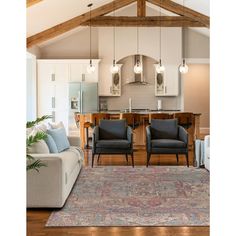 a living room filled with furniture next to a kitchen