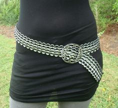 a woman wearing a black shirt with silver chains around her waist and an open belly