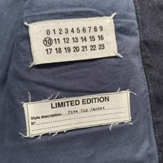 two tags on the back of a jacket that has been torn off and pinned to it