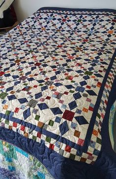 a bed with a blue and white quilt on it